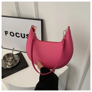 Minimalist magenta crescent shoulder bag with golden zipper and sleek faux leather finish