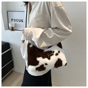 Stylish plush shoulder bag with brown cow print pattern shown on model in minimalist room