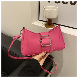 Détail du sac baguette rose fuchsia avec grande boucle argentée et texture cuir mat