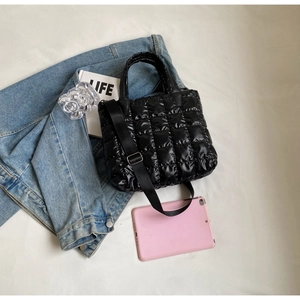 Détail du sac matelassé noir avec bandoulière en nylon réglable et texture rembourrée