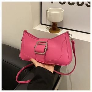 Détail d'un sac baguette en similicuir rose avec une grande boucle argentée et bandoulière