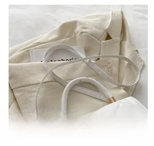 Détail de la bandoulière confortable et ferrures dorées sur sac blanc matelassé