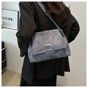 Detail showing grey suede-textured crossbody bag with chain strap and MIXXAIOI logo