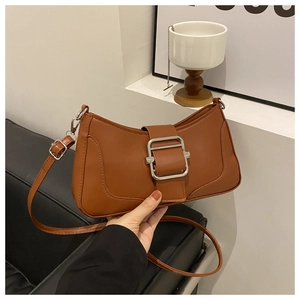 Détail du sac lune marron caramel avec boucle argentée et texture de cuir mat élégant