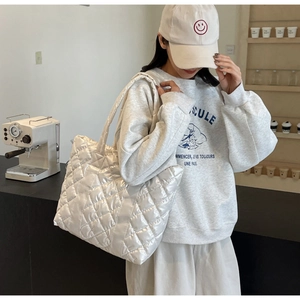 Detailed view of the large white quilted tote bag in glossy waterproof fabric