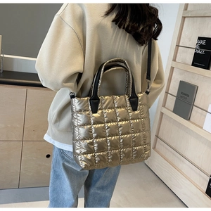 Détail du sac cabas matelassé or champagne avec poignée noire et bandoulière réglable