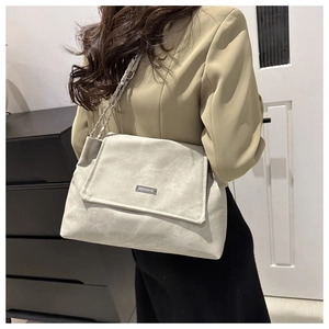 Chic beige soft PU leather tote bag with silver chain strap shown on a model