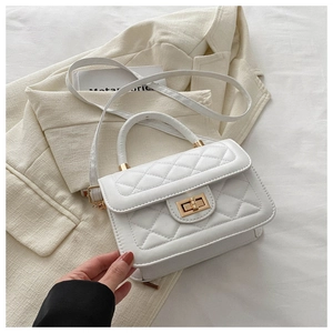 Gros plan du sac bandoulière blanc matelassé avec fermoir rotatif doré élégant
