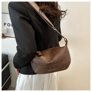 Detail of dark brown retro dumpling bag with textured PU leather and woven strap