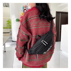 Détail du sac bandoulière en nylon noir avec logo imprimé et plusieurs fermetures éclair