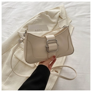 Détail d'un sac baguette chic en similicuir crème avec boucle carrée argentée