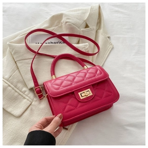 Détail du sac carré rose vif matelassé avec fermoir doré et bandoulière réglable