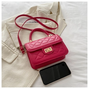 Détail macro du mini sac rose fuchsia en similicuir matelassé avec fermoir doré tournant