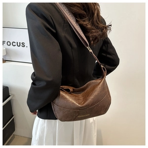 Detail of vintage dark brown PU leather hobo bag with ethnic geometric pattern strap