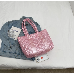 Close-up of pink metallic quilted tote bag with diamond stitching and shoulder straps
