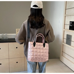 Détail du sac bandoulière rose en nylon matelassé avec bandoulière noire réglable