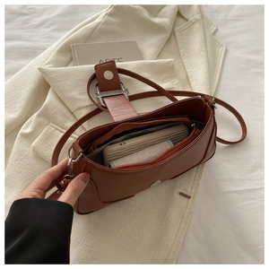 Vue intérieure du sac baguette marron montrant l'espace de rangement et la poche zippée