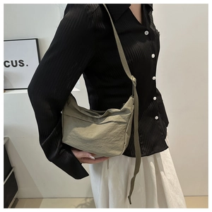 Adjustable wide strap and metal zipper detail of this olive green nylon crossbody bag