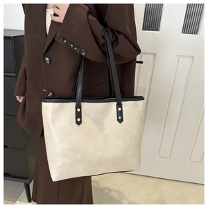 Detail of off-white vintage tote with cracked texture and gold rivets on the strap