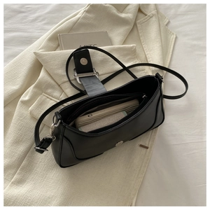 Vue intérieure du sac baguette noir mat montrant l'espace pour téléphone et portefeuille