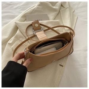 Vue intérieure du sac baguette kaki montrant le compartiment zippé et la boucle en métal