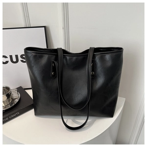Minimalist black PU leather tote bag with lychee texture on white platform