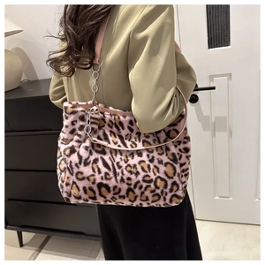 Detail of plush leopard print tote bag with pink leather strap and silver chain accent