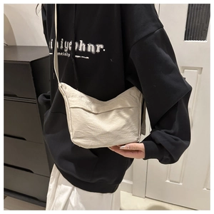 Detailed shot of a beige nylon crossbody tote bag worn with casual streetwear style