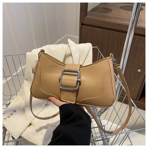 Détail du sac baguette en similicuir fauve avec boucle argentée et longue bandoulière