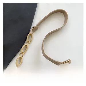 Detail of beige shoulder bag showing synthetic leather strap and resin chain link detail