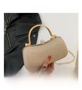 Detail view of champagne evening bag with gold handle and sparkling diamond lock clasp