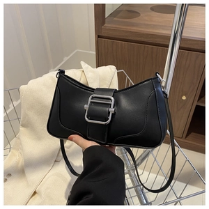 Détail d'un sac baguette en cuir noir mat avec une grande boucle carrée argentée