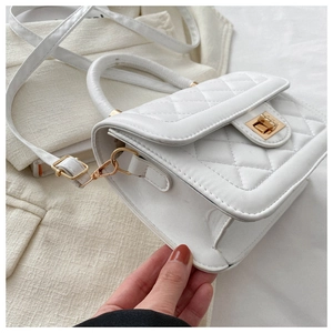Détail du sac à bandoulière matelassé blanc avec fermoir doré et bandoulière cuir