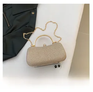 Top view of champagne gold glitter evening clutch with metal handle and smartphone for scale
