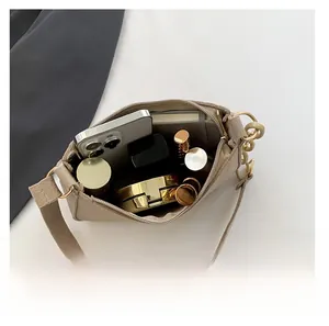Top view of beige crossbody bag interior showing phone and cosmetic storage capacity