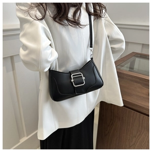 Détail du sac baguette minimaliste en cuir noir avec grande boucle argentée et surpiqûres