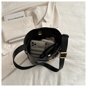 Interior view of black leather bucket bag showing large capacity and gold magnetic closure