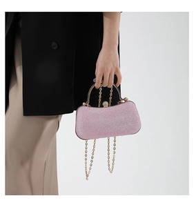 Macro detail of pink glitter evening clutch bag with diamond-encrusted sphere lock