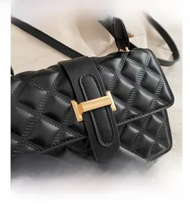 Detailed close-up of a black quilted shoulder bag with gold hardware and rhombic pattern