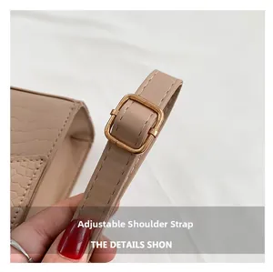 Close-up of adjustable shoulder strap with gold square buckle on beige crocodile handbag