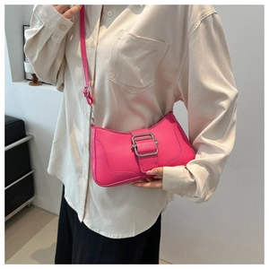 Gros plan d'un sac baguette rose vif avec une grande boucle argentée et bandoulière