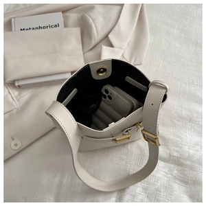 Top view of cream bucket bag showing magnetic closure and interior storage for phone
