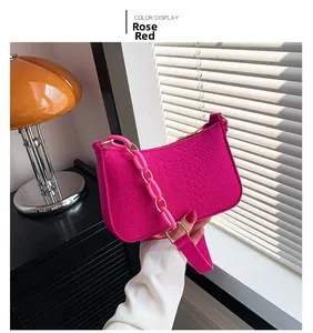 Detail of fuchsia hobo bag with animal skin texture and pink plastic chain strap
