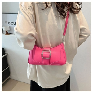 Sac baguette magenta chic avec boucle argentée présenté dans un décor lifestyle