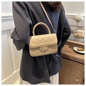 Détail d'un sac à bandoulière matelassé beige avec fermoir en métal doré sur mannequin