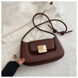 Detail view of brown textured shoulder bag featuring a square golden metal buckle clasp