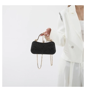 Detail of elegant black sequin evening bag with gold ring handle and diamond clasp