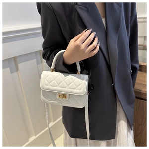 Détail d'un mini sac blanc matelassé avec fermoir doré rotatif et poignée élégante