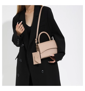 Détail du sac cabas beige avec poignée en cuir tressé et texture embossée croco