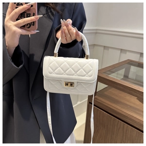 Détail du sac matelassé blanc en cuir avec fermoir rotatif doré et poignée élégante